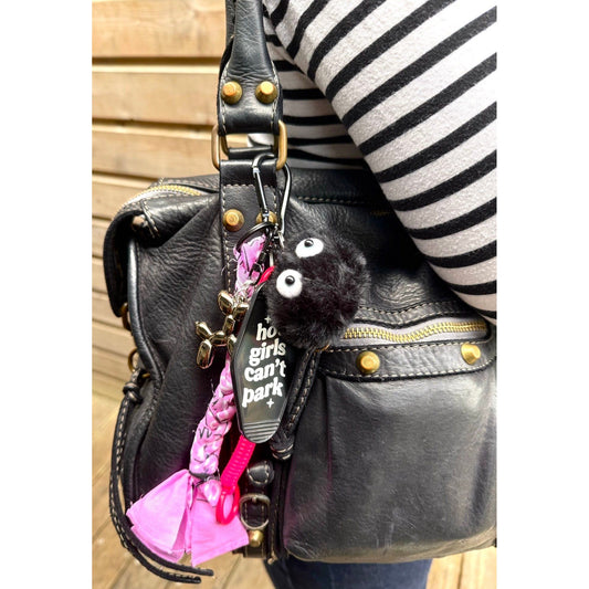 Grigri de sac rose et noir avec pompon poilu, plaque "hot girls can’t park" et pendentif chien ballon – Ømm – Accessoire fait main unique