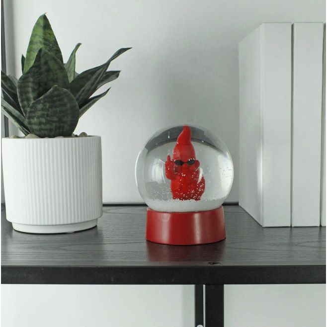 Boule à neige rouge avec figurine de nain insolent faisant un doigt d’honneur sous les flocons