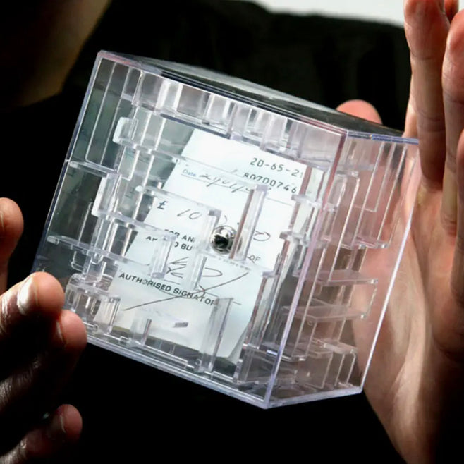 Tirelire labyrinthe transparente remplie de pièces avec parcours à bille