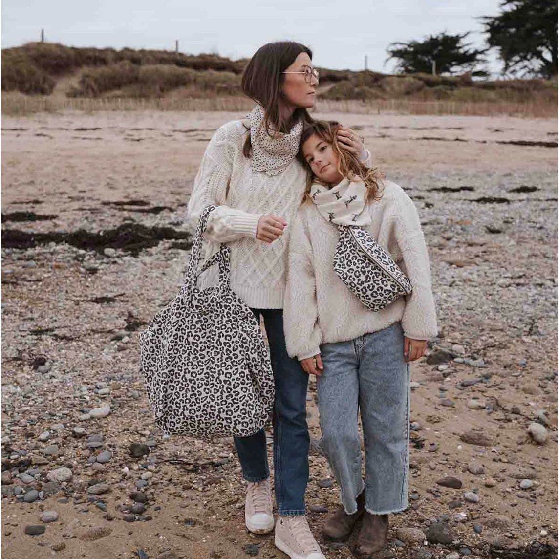 sac cabas Graou Grège Rose in April porté sur la plage, imprimé léopard noir sur fond écru