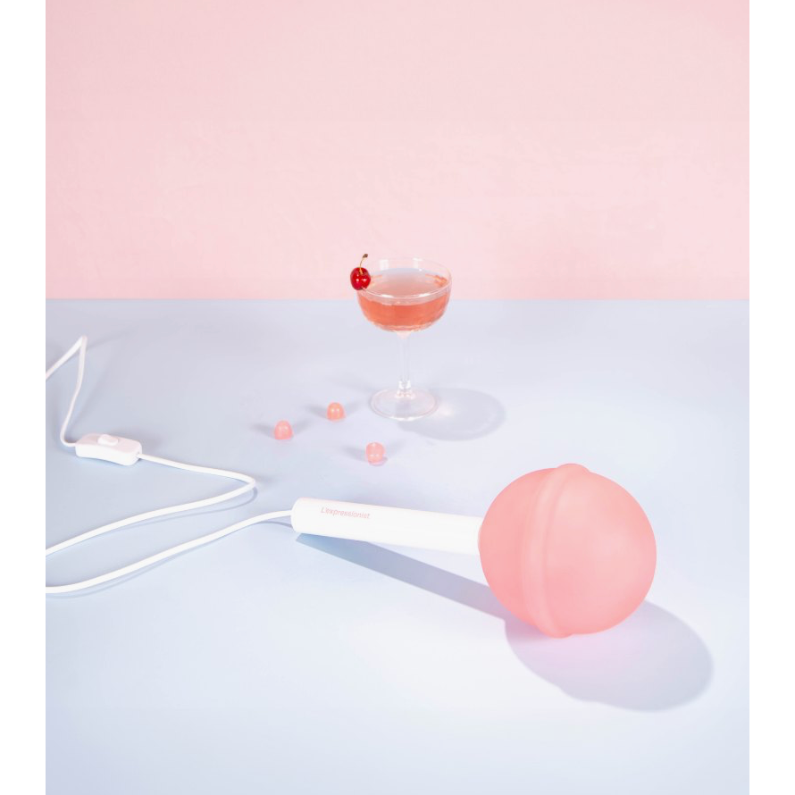 Lampe Sucette L'Expressionist rose à poser diffusant une lumière d'ambiance douce dans un intérieur contemporain