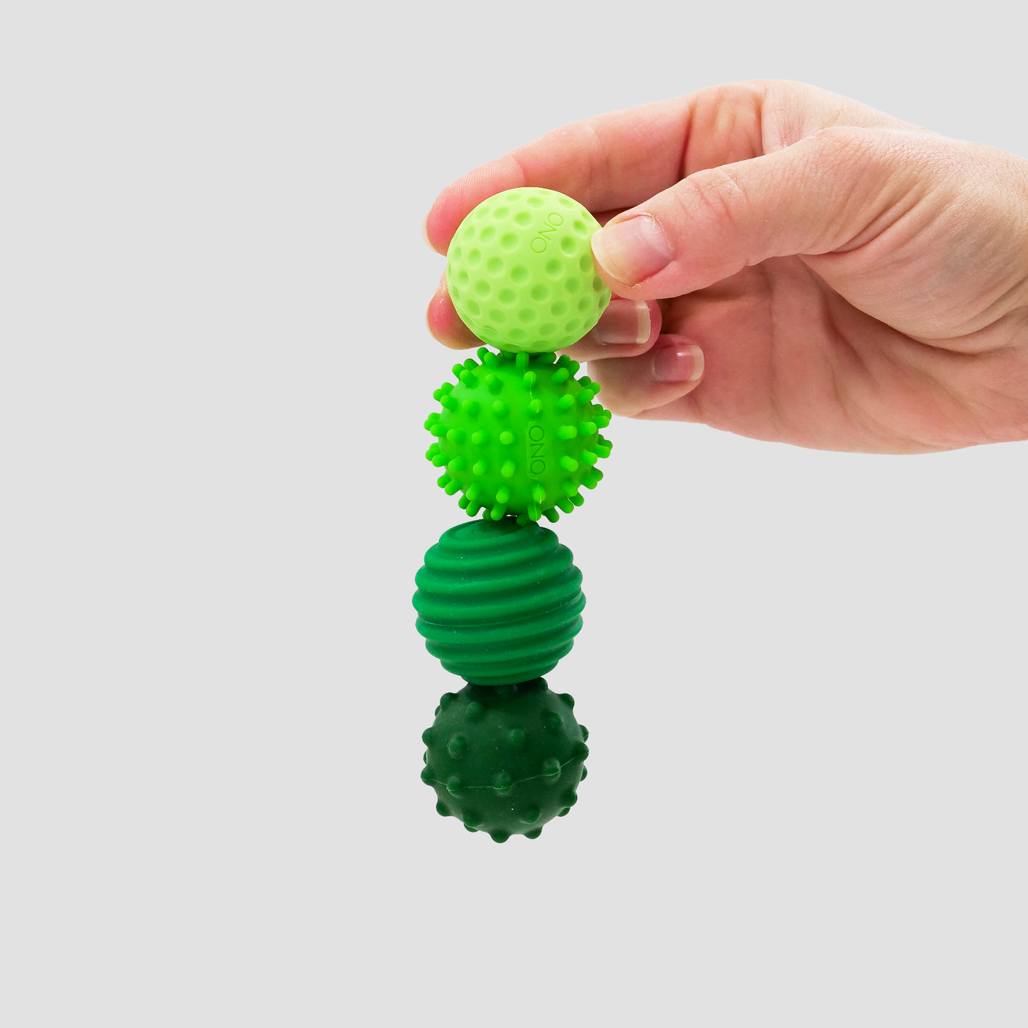 Pack ONO Émeraude de quatre balles magnétiques anti-stress en silicone vert avec textures variées dans un étui zippé noir