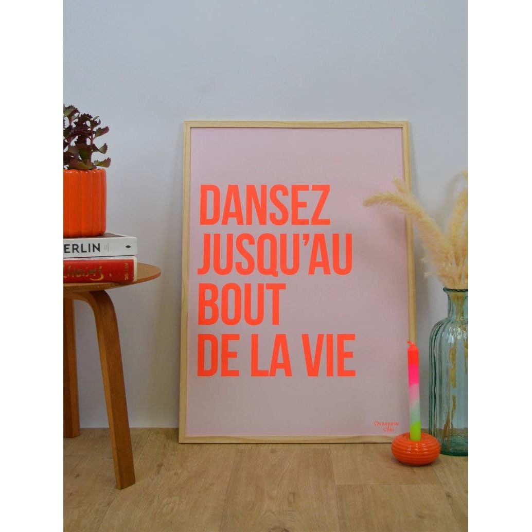 Affiche Dansez jusqu’au bout de la vie Chouquette Club 50 x 70 cm avec texte rouge sur fond rose pâle dans un intérieur contemporain