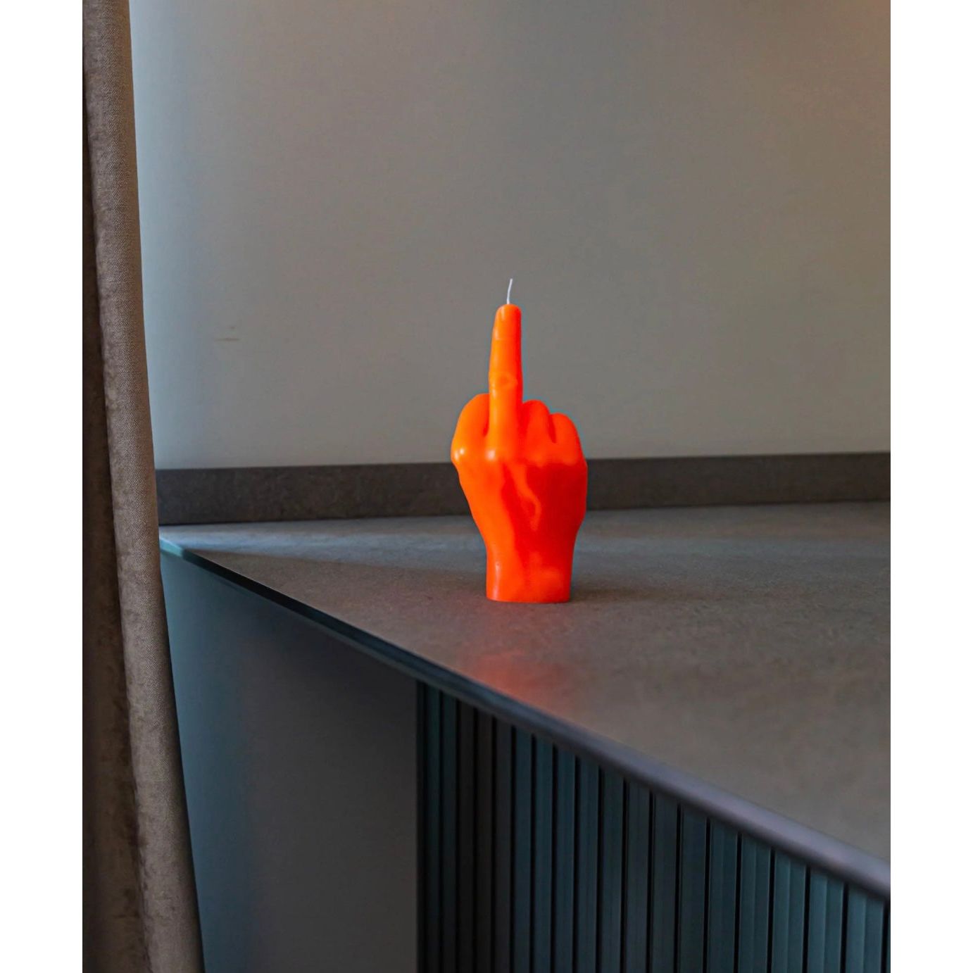 Bougie Candlehand fluo orange en forme de main faisant un doigt d’honneur