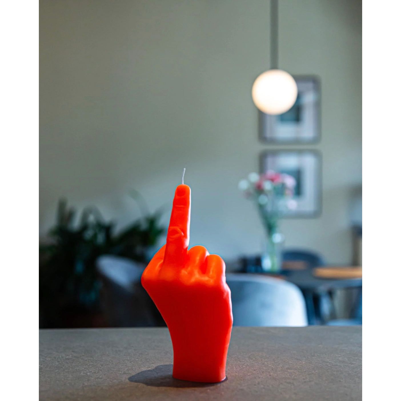 Bougie Candlehand fluo orange en forme de main faisant un doigt d’honneur