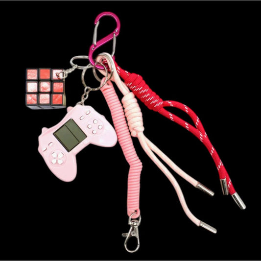 Grigri de sac rose avec mini manette Tetris, cube rotatif et cordons – Accessoire fun et geek.