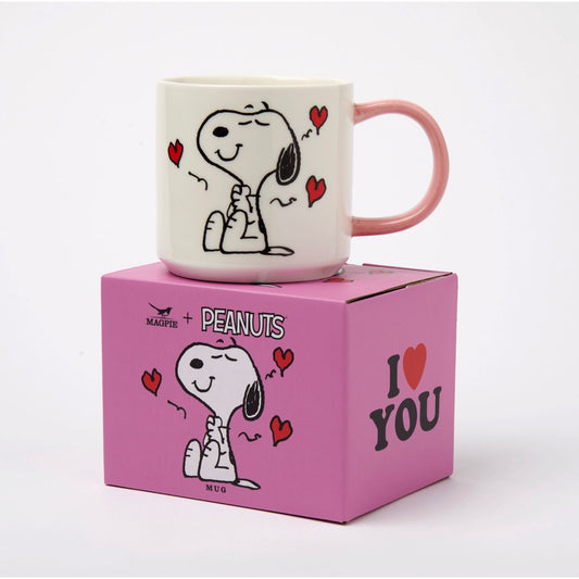 Mug Peanuts "I Love you" Magpie – Snoopy entouré de cœurs rouges, anse rose, sur boîte cadeau violette.