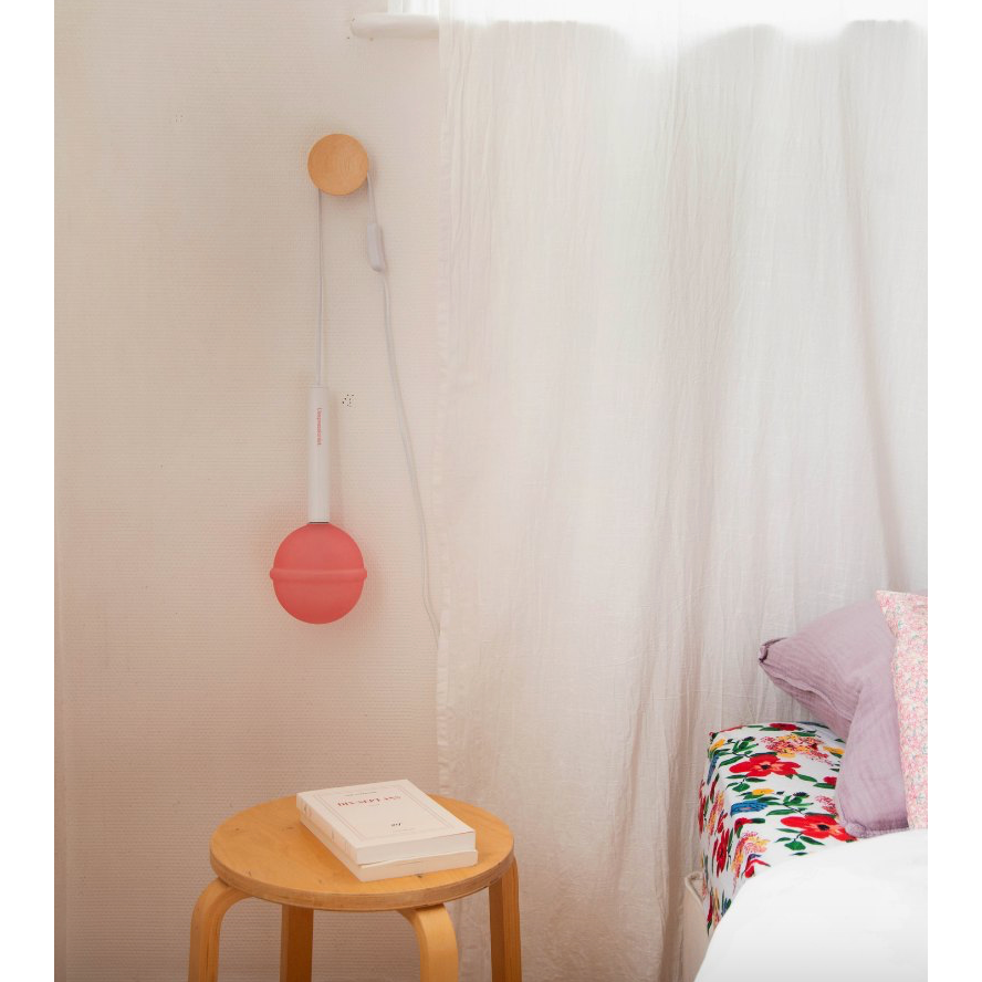 Lampe Sucette L'Expressionist rose à poser diffusant une lumière d'ambiance douce dans un intérieur contemporain