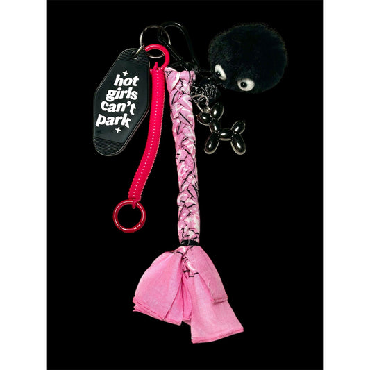 Grigri de sac rose et noir avec pompon poilu, plaque "hot girls can’t park" et pendentif chien ballon – Ømm – Accessoire fait main unique